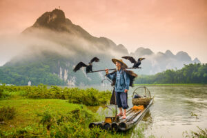 Hombre pescando cormoran en Yangshuo China